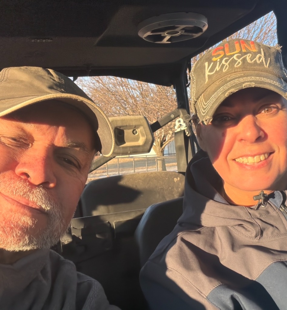 Ray and his wife Tammy smiling together in their side-by-side SxS vehicle near Lake Texoma.