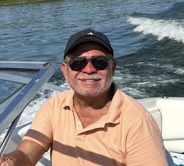 Ray Roman driving a boat across the waters of Lake Texoma on a sunny afternoon.